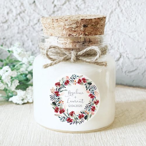 Bougie personnalisée mariage décorée d’une couronne florale rouge et de feuillage eucalyptus.