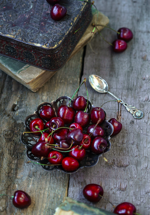 Cerises noires et objets d'officine inspirant la bougie parfumée Cerise Noire